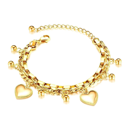A luxurious 18K gold-plated charm bracelet featuring a mix of box and link chains, adorned with small gold beads and two heart-shaped pendants. The bracelet has an adjustable extension chain for a customizable fit, making it a stylish and versatile accessory for any occasion.