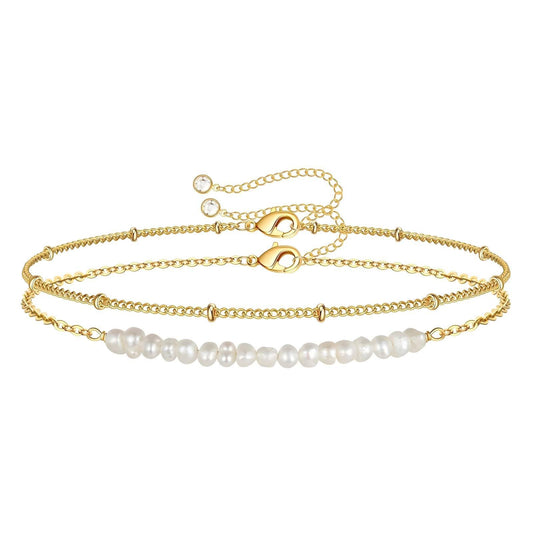 "Elegant dual-layer gold and pearl bracelet featuring a box chain and herringbone gold chain. Made with 18K gold-plated stainless steel and imitation pearls. Waterproof, tarnish-resistant, and adjustable with a lobster clasp and extender chain."
