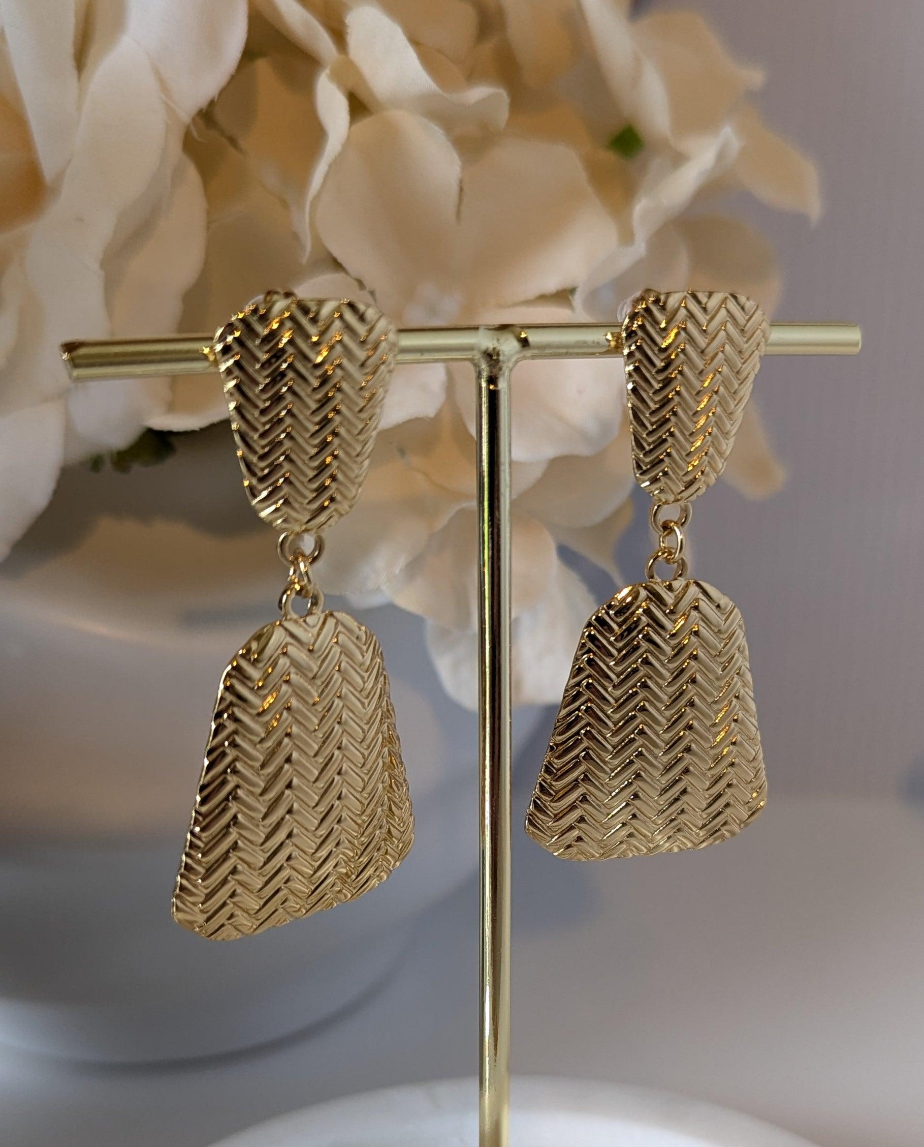 Braided Boho Chic Dangle Earrings displayed on a jewelry rack, highlighting their 18k gold-plated stainless steel finish and unique boho design.