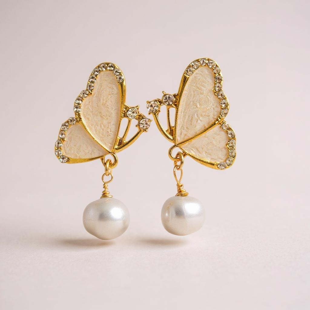 Butterfly wing earrings with pearls hanging from each wing.