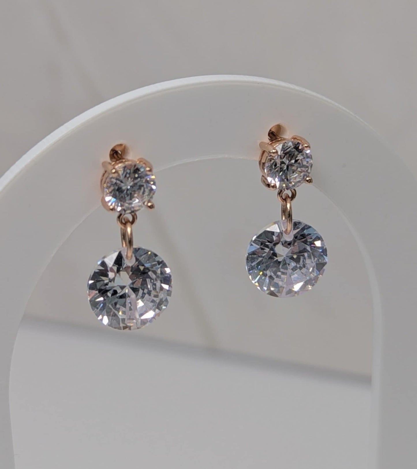 Rose Gold Cubic Zirconia Dangle earrings hanging on a earrings display