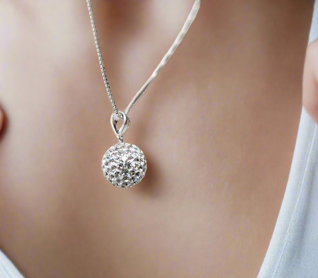Sterling silver necklace with pavé crystal ball pendant on a white background