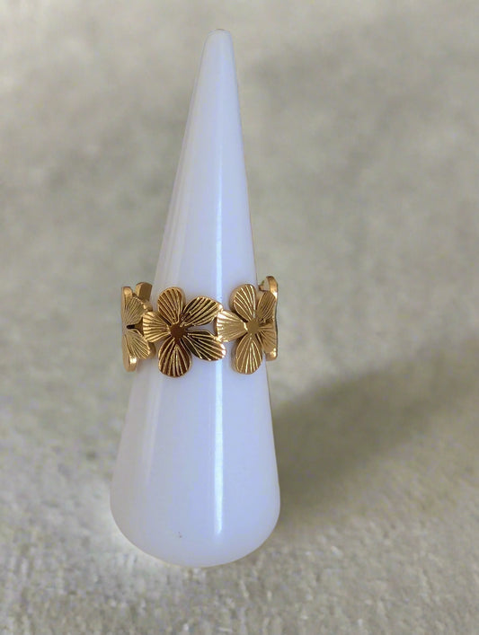gold adjustable flower ring on a white ring display