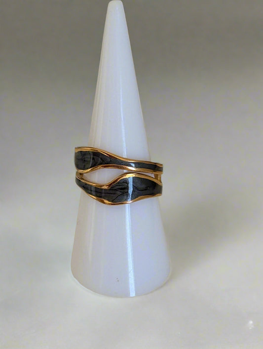 Elegant 18K gold-plated statement ring with a bold, wavy design featuring black enamel accents. Made from durable stainless steel, this adjustable ring is waterproof, tarnish-resistant, and hypoallergenic. A modern and sophisticated accessory for any occasion.