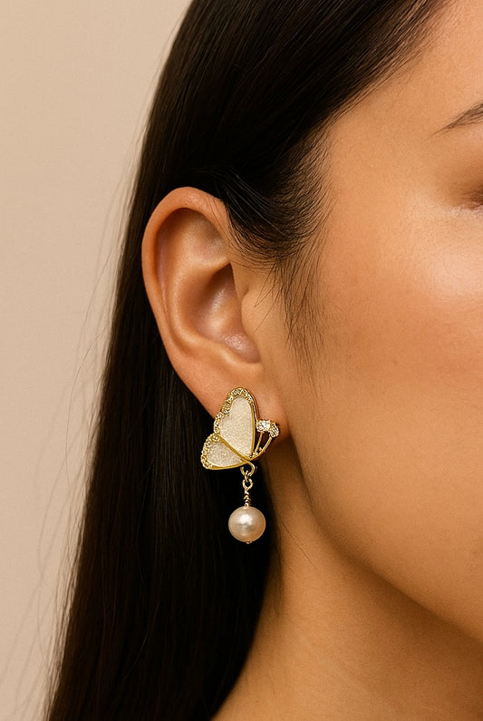 Model of woman wearing butterfly earrings with freshwater pearls.  
