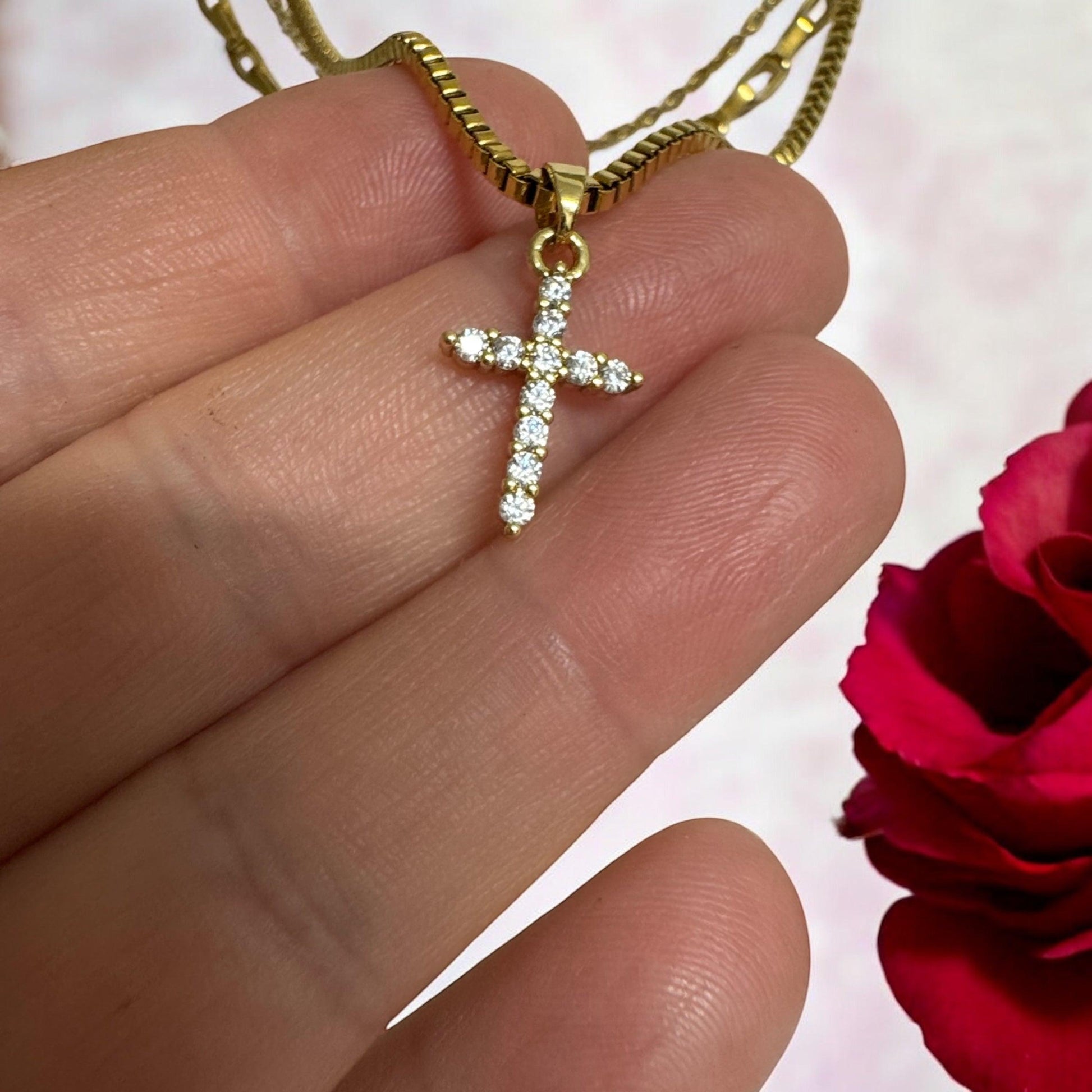 Close-up of triple layered gold necklace with cross pendant on display bust – waterproof, non-tarnish, 18K gold-plated chains in varying styles"