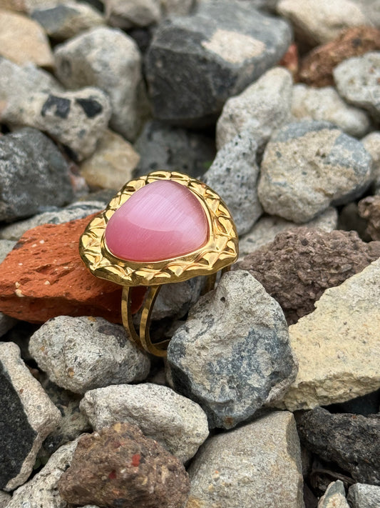 Pink heart Adjustable Ring 18k Gold Plated Waterproof Ring, Pink Rhinestone heart ring displayed amongst small gravel rocks.