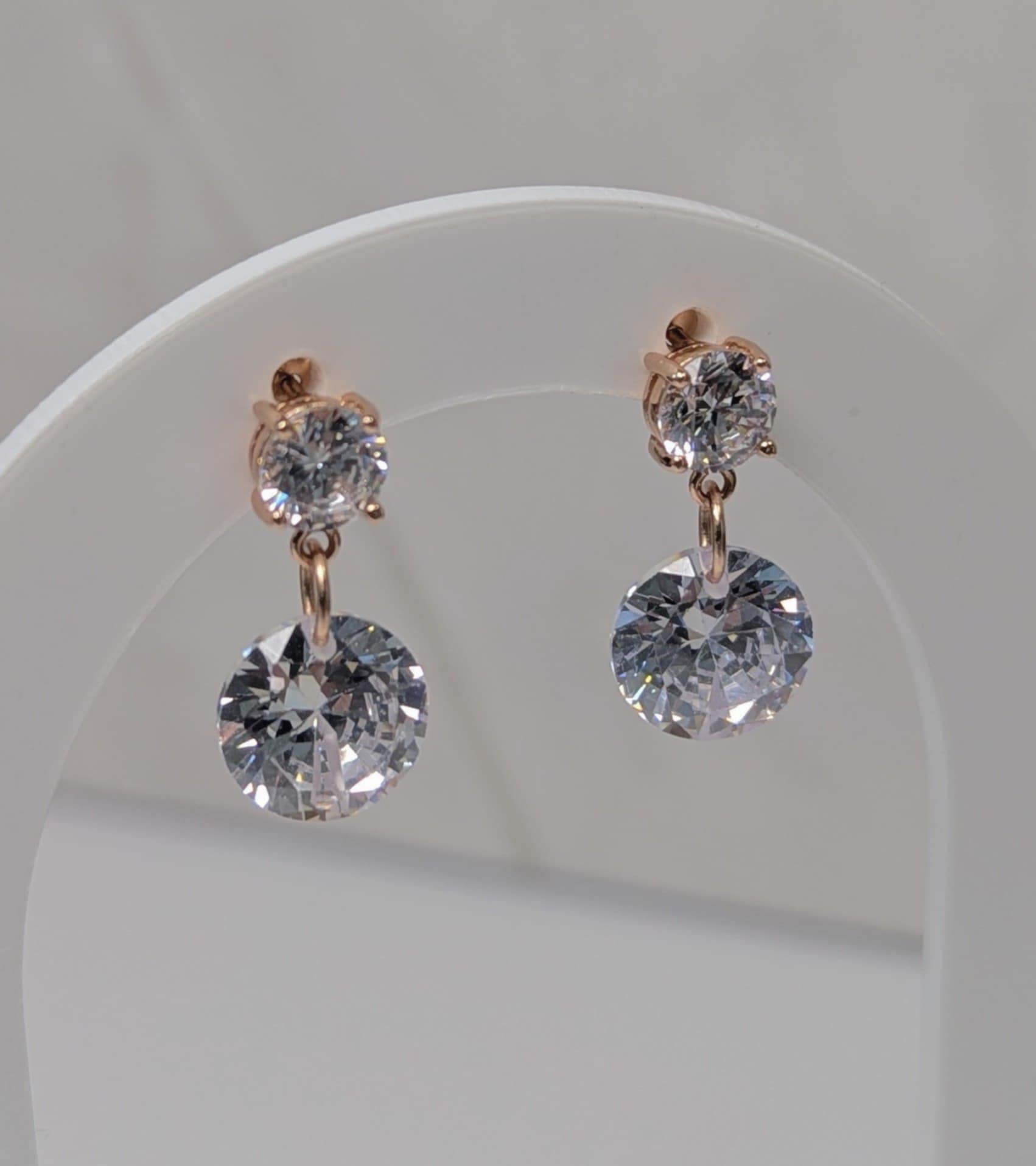 Rose Gold Cubic Zirconia Dangle earrings hanging on a earrings display